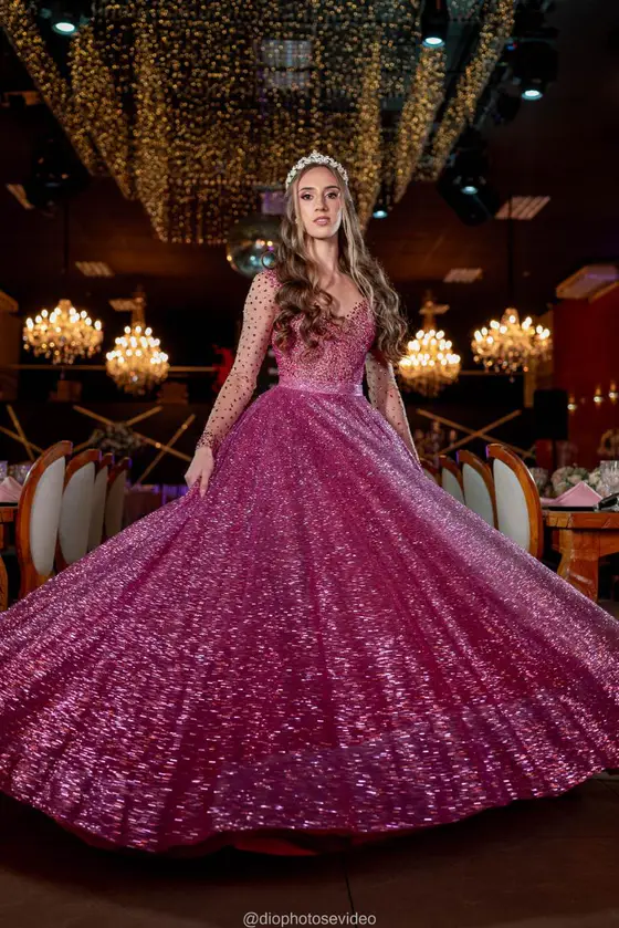 Debutante girando o vestido pink brilhante no salão de lustres